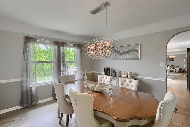8014 Maureen Dr, Cranberry Twp, PA 16066 - dining space featuring a chandelier, plenty of natural light, arched walkways, and wood finished floors