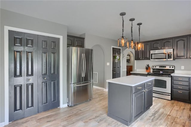 8014 Maureen Dr, Cranberry Twp, PA 16066 - kitchen featuring appliances with stainless steel finishes, arched walkways, light countertops, and light wood finished floors