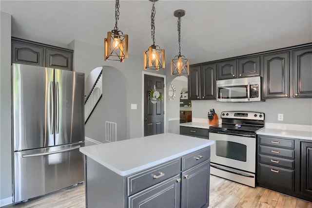 8014 Maureen Dr, Cranberry Twp, PA 16066 - kitchen featuring appliances with stainless steel finishes, arched walkways, light countertops, and light wood-style floors