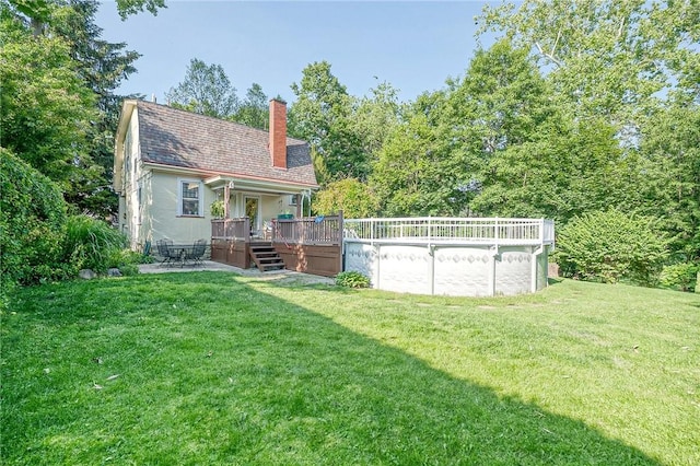 31 Nicholson St, Crafton, PA 15205 - back of house with a wooden deck, a chimney, a lawn, and an outdoor pool
