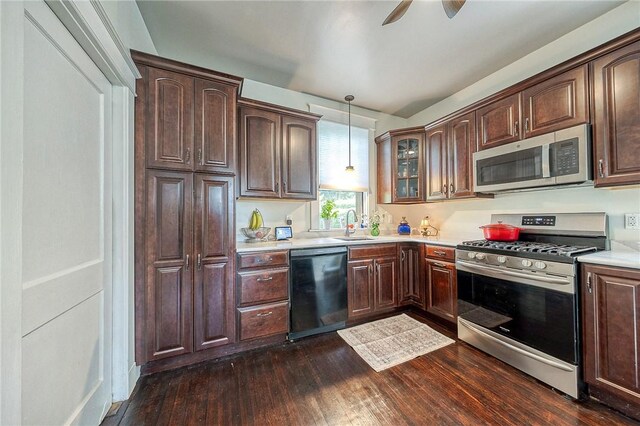 31 Nicholson St, Crafton, PA 15205 - kitchen with appliances with stainless steel finishes, dark wood-type flooring, decorative light fixtures, glass insert cabinets, and dark brown cabinets