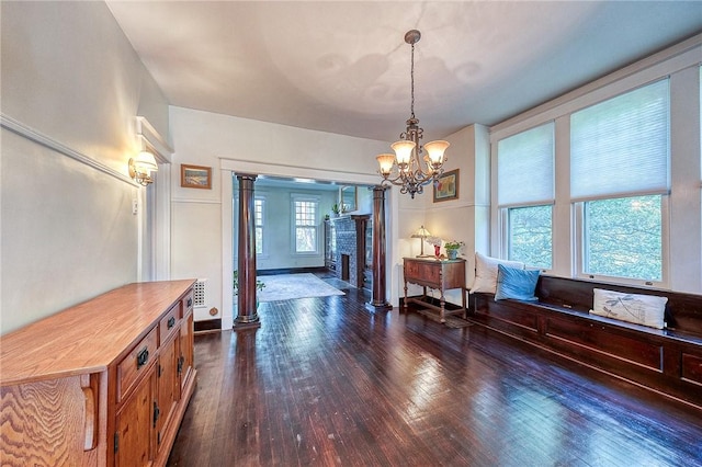 31 Nicholson St, Crafton, PA 15205 - dining room with dark wood-style floors, a chandelier, a fireplace, and decorative columns