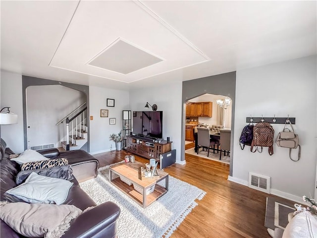 4330 Overhill St, Bethel Park, PA 15102 - living area featuring arched walkways, light wood-type flooring, stairs, baseboards, and a chandelier