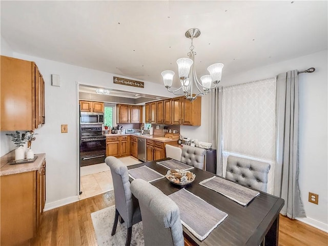 4330 Overhill St, Bethel Park, PA 15102 - dining room with a chandelier, light wood-type flooring, and baseboards