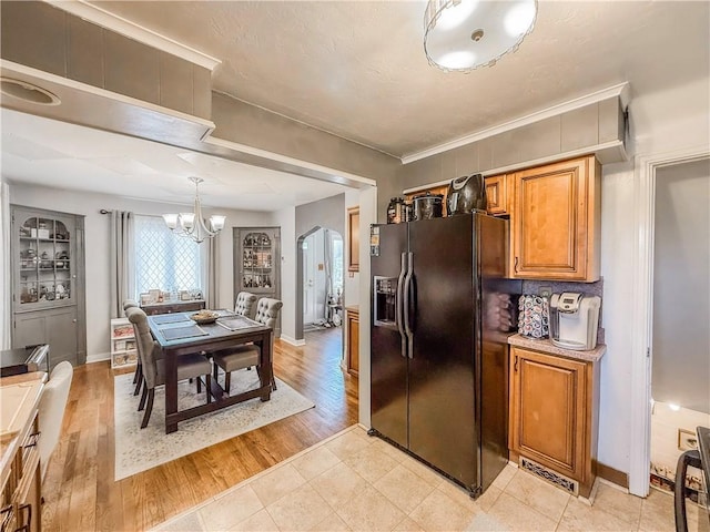 4330 Overhill St, Bethel Park, PA 15102 - kitchen with black refrigerator with ice dispenser, a chandelier, brown cabinets, baseboards, and decorative light fixtures