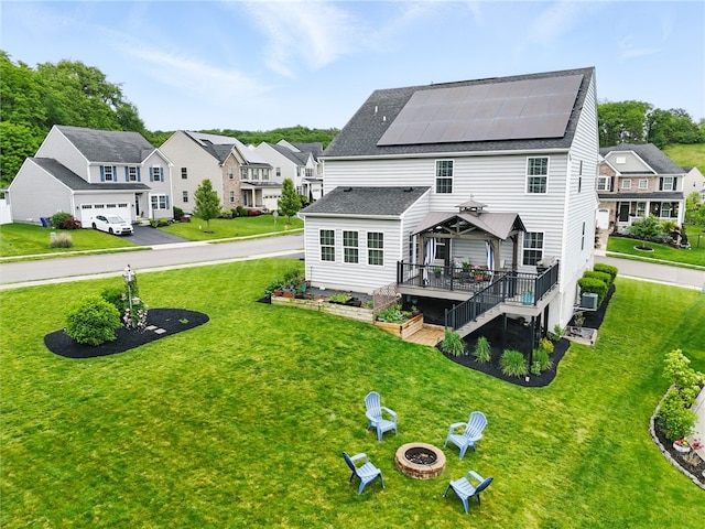 407 Isabella Ct, Zelienople Boro, PA 16063 - rear view of property featuring solar panels, an outdoor fire pit, a wooden deck, a residential view, and a lawn