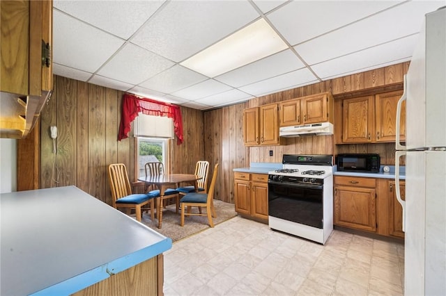600 Scott St, Penn Twp Wml, PA 15675 - kitchen with white appliances, under cabinet range hood, wooden walls, light countertops, and light flooring