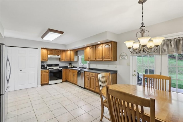1025 Manor Vue Ct, Murrysville, PA 15626 - kitchen featuring appliances with stainless steel finishes, under cabinet range hood, a chandelier, brown cabinetry, and dark countertops