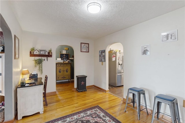 5 Beach St, Centerville, PA 15358 - dining area featuring arched walkways, a textured ceiling, light wood-style floors, and baseboards