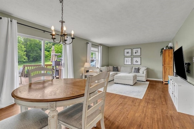 309 Wildflower Ct, Ross Twp, PA 15202 - dining space with a chandelier, wood finished floors, healthy amount of natural light, and a textured ceiling