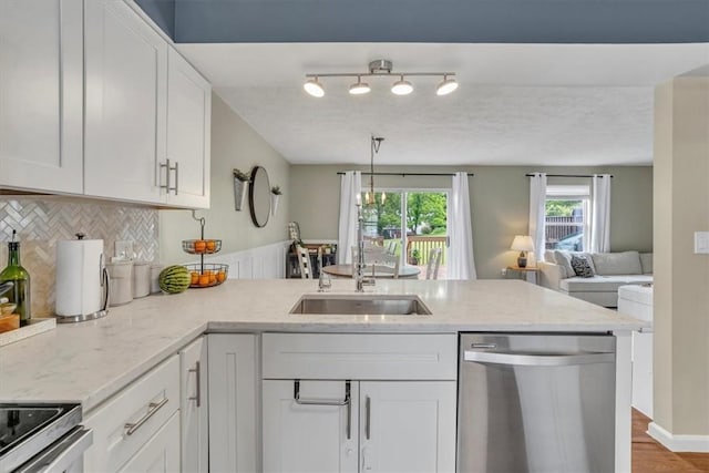 309 Wildflower Ct, Ross Twp, PA 15202 - kitchen featuring stainless steel dishwasher, a peninsula, decorative backsplash, a sink, and white cabinetry