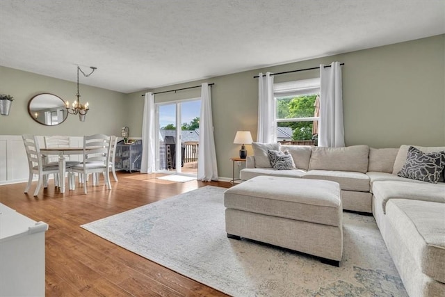 309 Wildflower Ct, Ross Twp, PA 15202 - living area with wood finished floors, a chandelier, and a textured ceiling