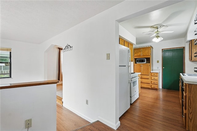 1122 Tyndall St, Sheraden, PA 15204 - kitchen with white appliances, ceiling fan, wood finished floors, light countertops, and arched walkways