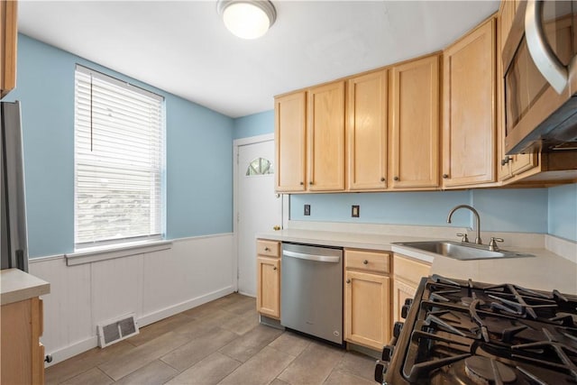 1313 Virginia Ave, Mt Washington, PA 15211 - kitchen featuring appliances with stainless steel finishes, light brown cabinetry, a sink, light countertops, and a wainscoted wall