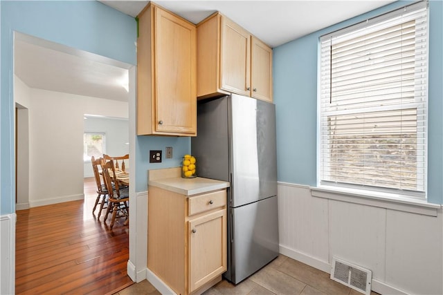 1313 Virginia Ave, Mt Washington, PA 15211 - kitchen with freestanding refrigerator, light brown cabinetry, wainscoting, light countertops, and light wood-style floors