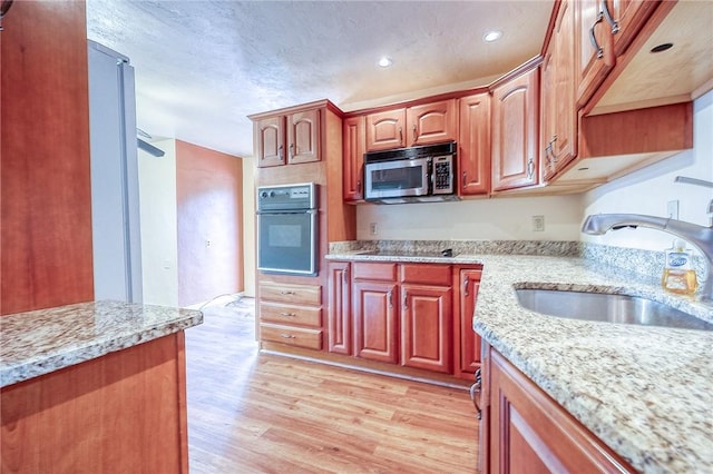 3333 Walther Ln, Upper St Clair, PA 15241 - kitchen with black appliances, a sink, light wood-style floors, light stone countertops, and recessed lighting