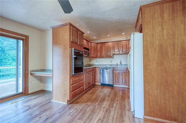 3333 Walther Ln, Upper St Clair, PA 15241 - kitchen featuring stainless steel appliances, light wood-style flooring, a sink, light countertops, and brown cabinets