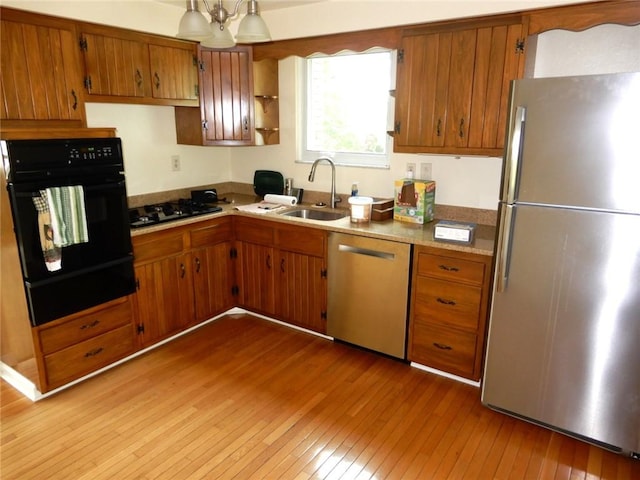 204 Stonebrook Dr, Peters Twp, PA 15317 - kitchen with black appliances, a warming drawer, a sink, light wood-style floors, and brown cabinetry