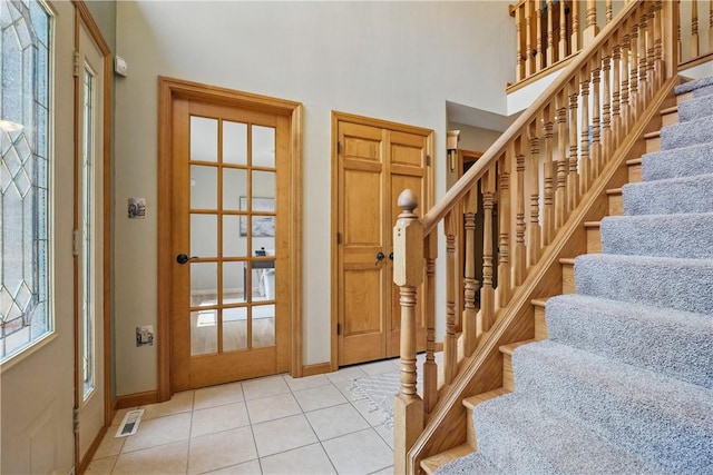 807 Rembrandt Cir, Hempfield Twp Wml, PA 15642 - entryway with light tile patterned floors, stairway, baseboards, and a high ceiling