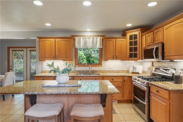 807 Rembrandt Cir, Hempfield Twp Wml, PA 15642 - kitchen with appliances with stainless steel finishes, a sink, a breakfast bar, light tile patterned floors, and light stone counters