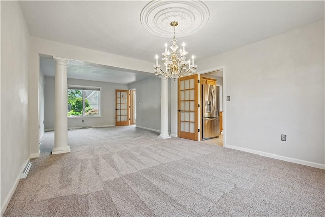 807 Rembrandt Cir, Hempfield Twp Wml, PA 15642 - spare room featuring ornate columns, light colored carpet, a chandelier, and baseboards