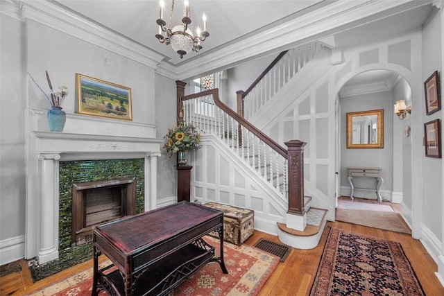 241 S Atlantic Ave, Friendship Park, PA 15224 - living area featuring wood finished floors, a chandelier, a tile fireplace, crown molding, and arched walkways
