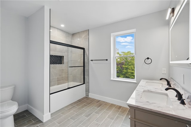 346 45th St, Lawrenceville, PA 15201 - full bath with baseboards, double vanity, toilet, bath / shower combo with glass door, and wood tiled floors