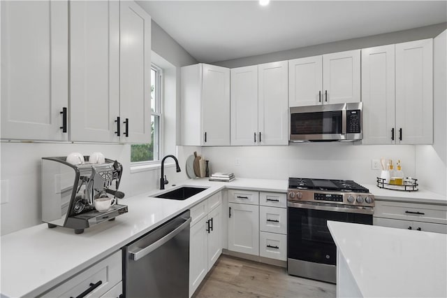 346 45th St, Lawrenceville, PA 15201 - kitchen featuring appliances with stainless steel finishes, a sink, light countertops, white cabinetry, and light wood-style flooring