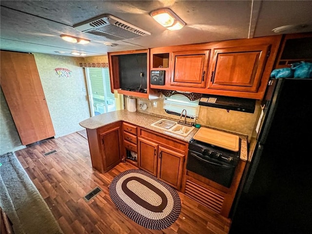 126 Dockside Ln, Bradys Bend Twp, PA 16028 - kitchen with black appliances, a sink, brown cabinets, light countertops, and wood finished floors