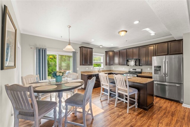 210 Brae Glen Dr, North Strabane, PA 15317 - kitchen with stainless steel appliances, dark brown cabinets, a kitchen island, crown molding, and a kitchen breakfast bar