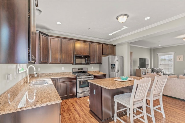 210 Brae Glen Dr, North Strabane, PA 15317 - kitchen with stainless steel appliances, a sink, open floor plan, a kitchen bar, and light wood-type flooring