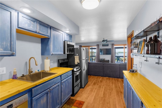 7832 Chase Dr, Shenango-Cra, PA 16134 - kitchen with butcher block countertops, appliances with stainless steel finishes, a sink, blue cabinets, and light wood-style flooring