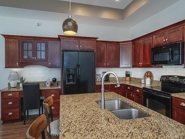 138 Cobblestone, Ohio Twp, PA 15237 - kitchen with black appliances, a sink, decorative light fixtures, dark wood-style floors, and reddish brown cabinets