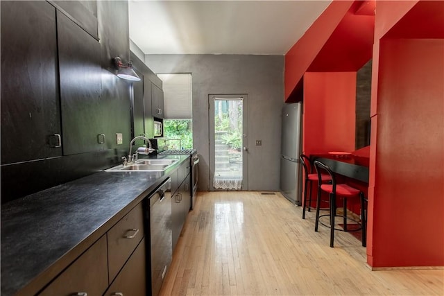 6542 Dalzell Pl, Squirrel Hill, PA 15217 - kitchen featuring stainless steel appliances, light wood-type flooring, a sink, and dark countertops