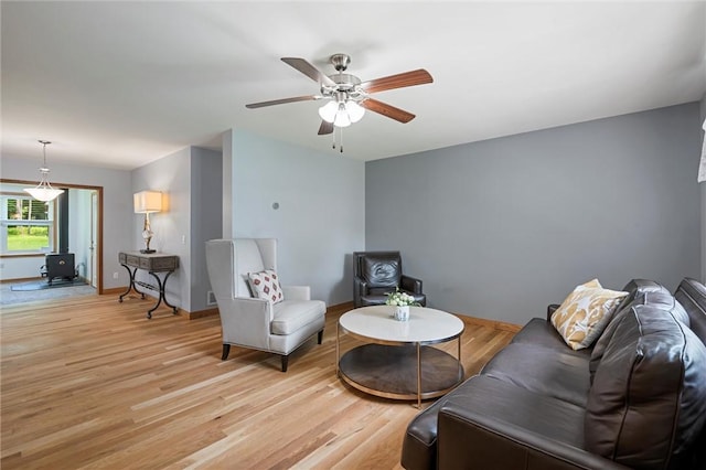 310 Laurel Ln, Leeper, PA 16233 - living area with light wood-style flooring, a ceiling fan, baseboards, and a wood stove