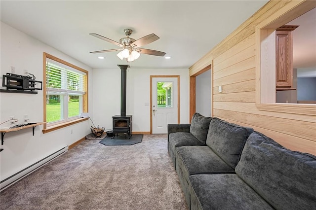 310 Laurel Ln, Leeper, PA 16233 - living room with a wood stove, a baseboard heating unit, a ceiling fan, carpet flooring, and plenty of natural light