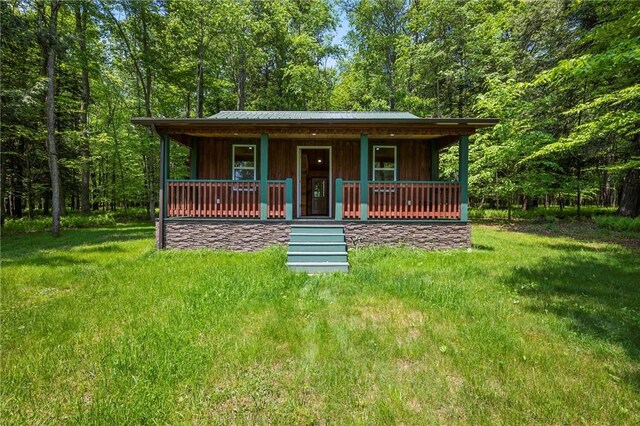 310 Laurel Ln, Leeper, PA 16233 - rustic home featuring covered porch, board and batten siding, and a wooded view
