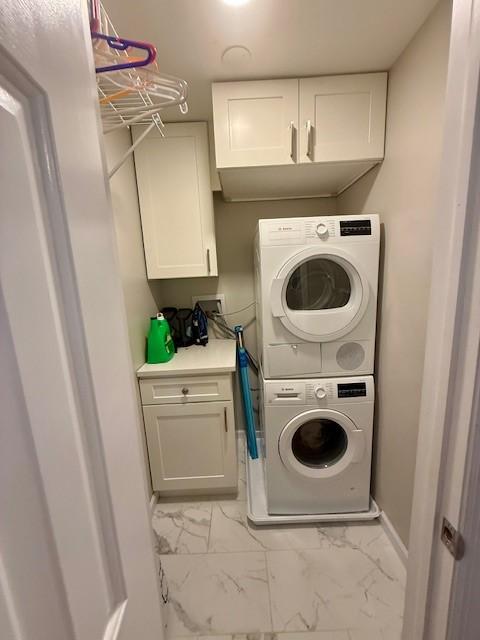 204 Thornberry Cir, Mt Lebanon, PA 15234 - washroom featuring stacked washer and clothes dryer, light marble finish floors, and cabinet space
