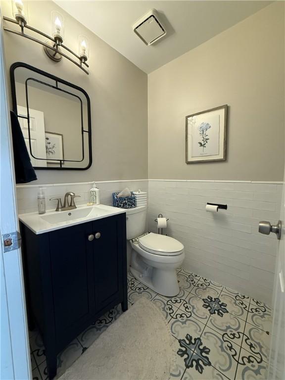 204 Thornberry Cir, Mt Lebanon, PA 15234 - bathroom featuring tile walls, a wainscoted wall, toilet, tile patterned floors, and vanity