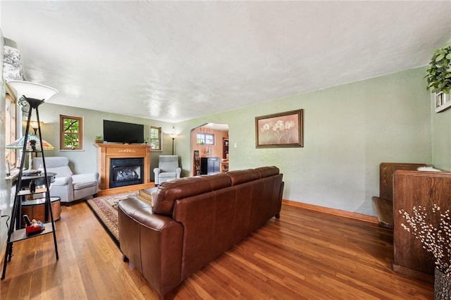 4335 Frank St, Whitehall, PA 15227 - living room with a fireplace, arched walkways, wood finished floors, and baseboards