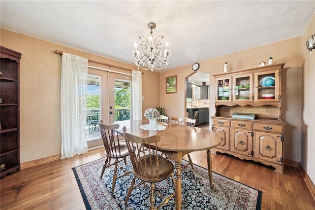 4335 Frank St, Whitehall, PA 15227 - dining room featuring arched walkways, light wood-type flooring, french doors, and a chandelier
