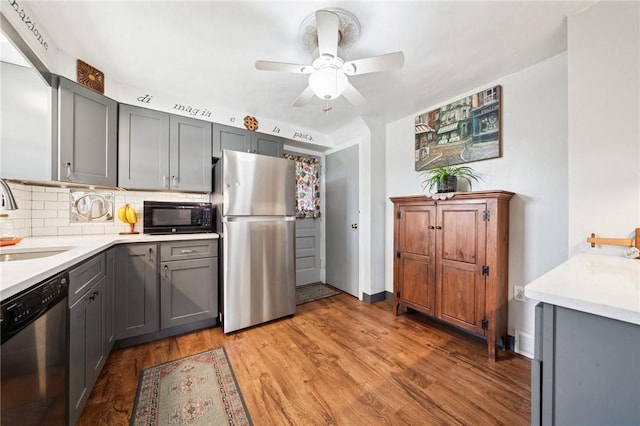 4335 Frank St, Whitehall, PA 15227 - kitchen with appliances with stainless steel finishes, gray cabinets, a sink, tasteful backsplash, and light countertops