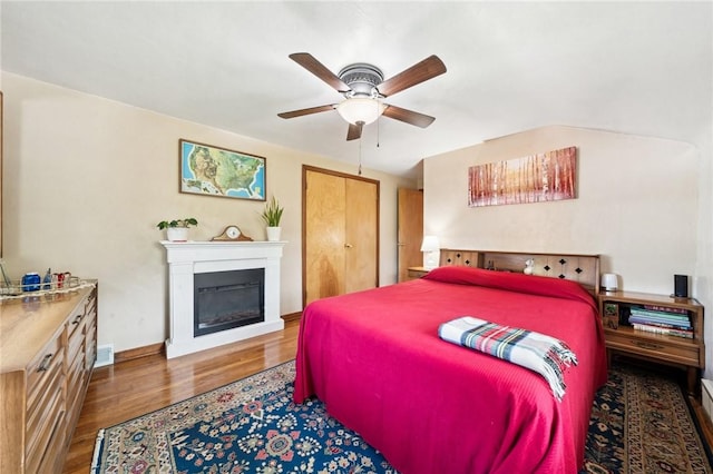 4335 Frank St, Whitehall, PA 15227 - bedroom with wood finished floors, a glass covered fireplace, a ceiling fan, and baseboards