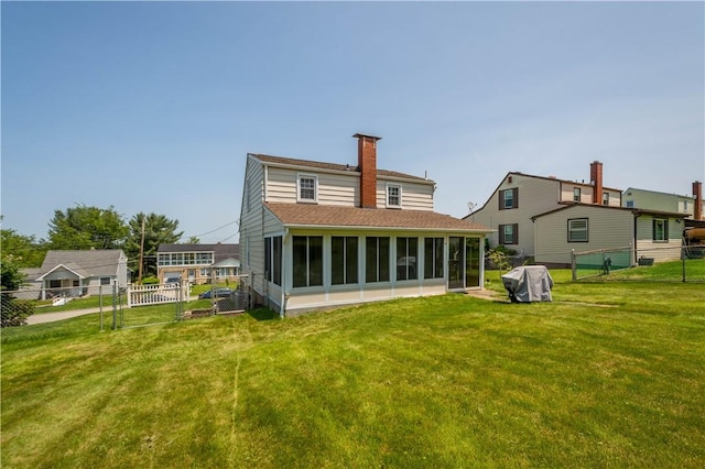 711 Ascension Dr W, West Mifflin, PA 15122 - back of house with a sunroom, a chimney, a shingled roof, and a gate