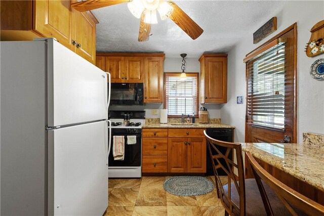 711 Ascension Dr W, West Mifflin, PA 15122 - kitchen featuring black appliances, a ceiling fan, brown cabinets, a sink, and light stone countertops