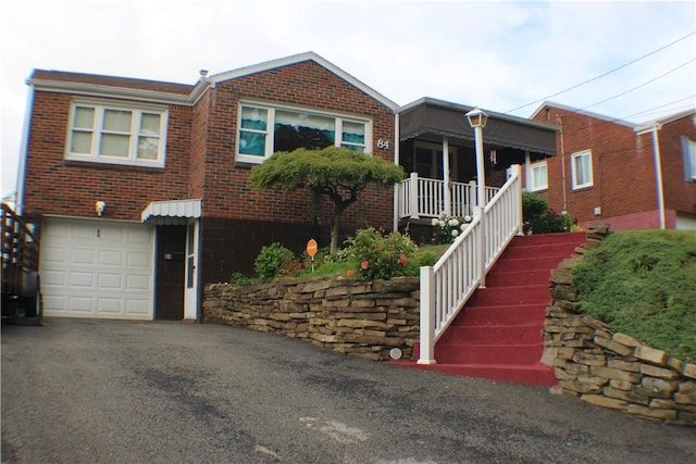 84 Pennsylvania Ave, Monessen, PA 15062 - view of front of house with brick siding, a garage, and asphalt driveway