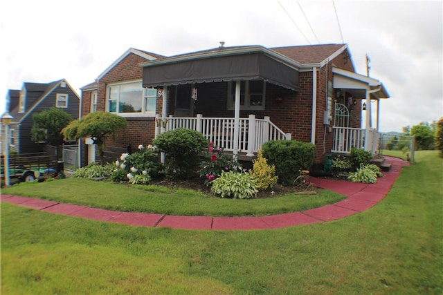 84 Pennsylvania Ave, Monessen, PA 15062 - view of front of home featuring brick siding, covered porch, and a front lawn