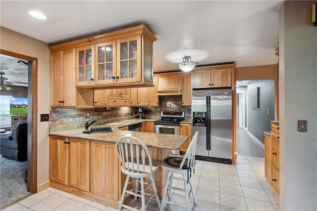 829 Hecla Rd, Mount Pleasant Twp Wml, PA 15666 - kitchen with stainless steel appliances, a sink, a peninsula, light tile patterned floors, and decorative backsplash