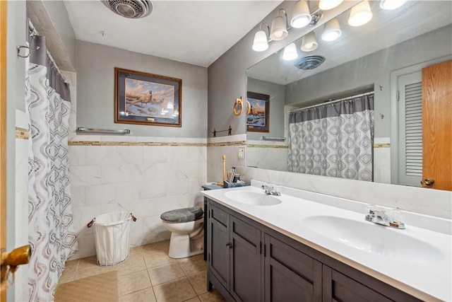 829 Hecla Rd, Mount Pleasant Twp Wml, PA 15666 - full bath featuring tile walls, toilet, tile patterned flooring, double vanity, and wainscoting