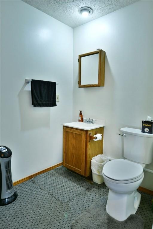 3062 Longview Rd, Hermitage, PA 16148 - half bath with vanity, toilet, a textured ceiling, and baseboards